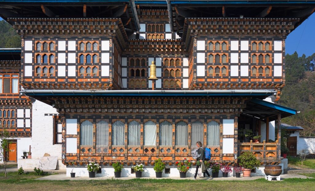 Impresionante fachada de madera con decoraciones de un Homestay/farmhouses o casa rural en Punakha, en Bután (Bhutan)