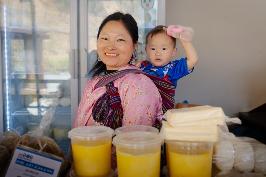 Mujer butanesa con su hija, vendiendo quesos en su puesto del mercado Farmers Market en Timbu (Thimphu) la capital de Bután (Bhutan)