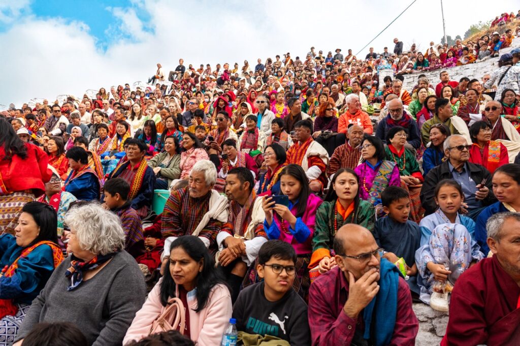 Familias butanesas en el patio exterior para presenciar los bailes del Tsechu de Paro en Butan (Bhutan)