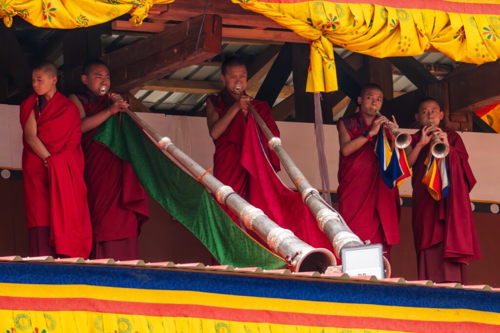 Monjes tocan los dungchem (trompetas largas) durante el festival Tsechu